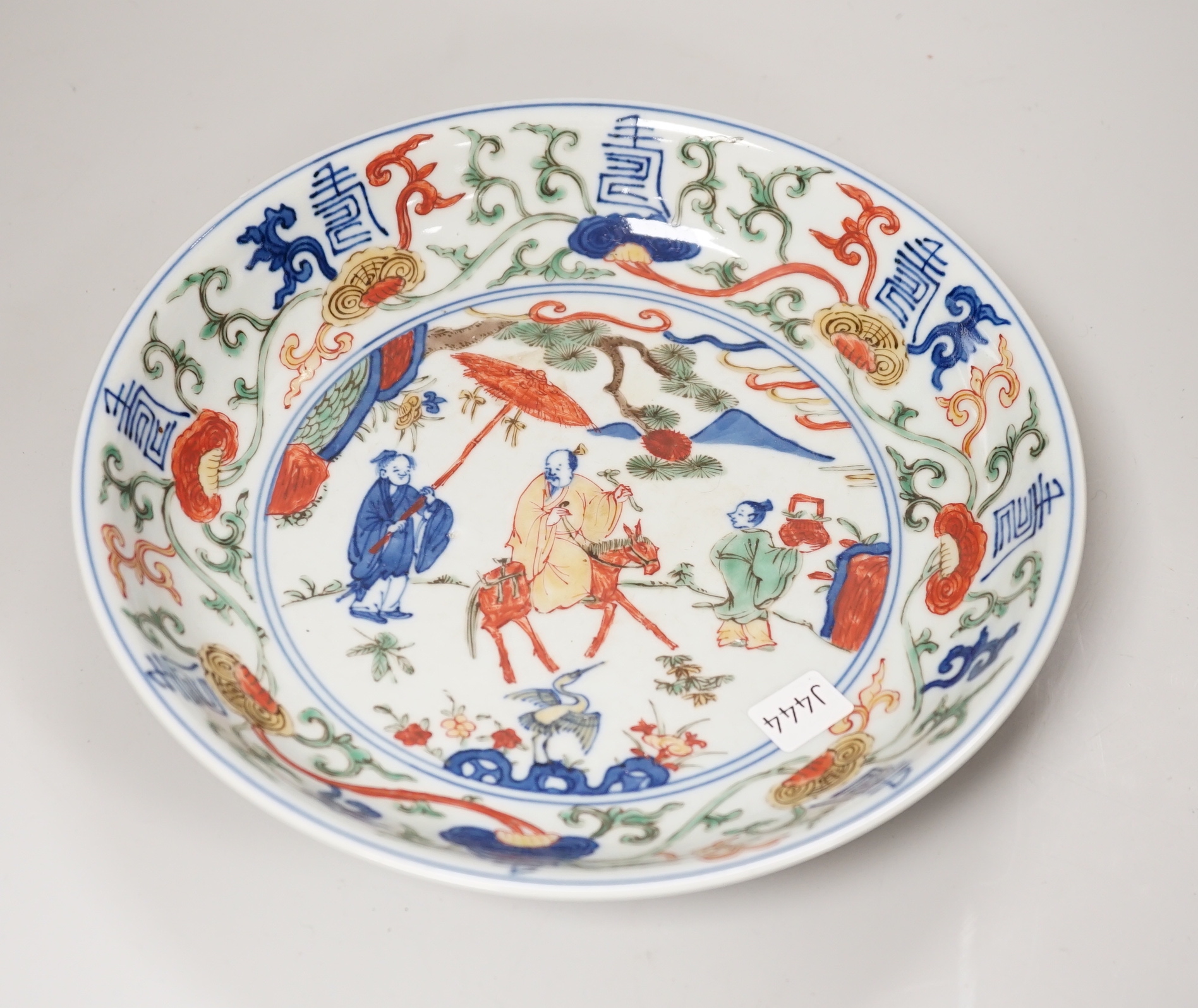 A Chinese wucai shallow dish hand painted with figures and flowers, housed in a fitted case, 23cm in diameter